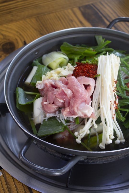 끓이기 전 와촌돼지찌개 — 돼지고기, 팽이버섯, 파, 고춧가루를 담은 넓은 냄비