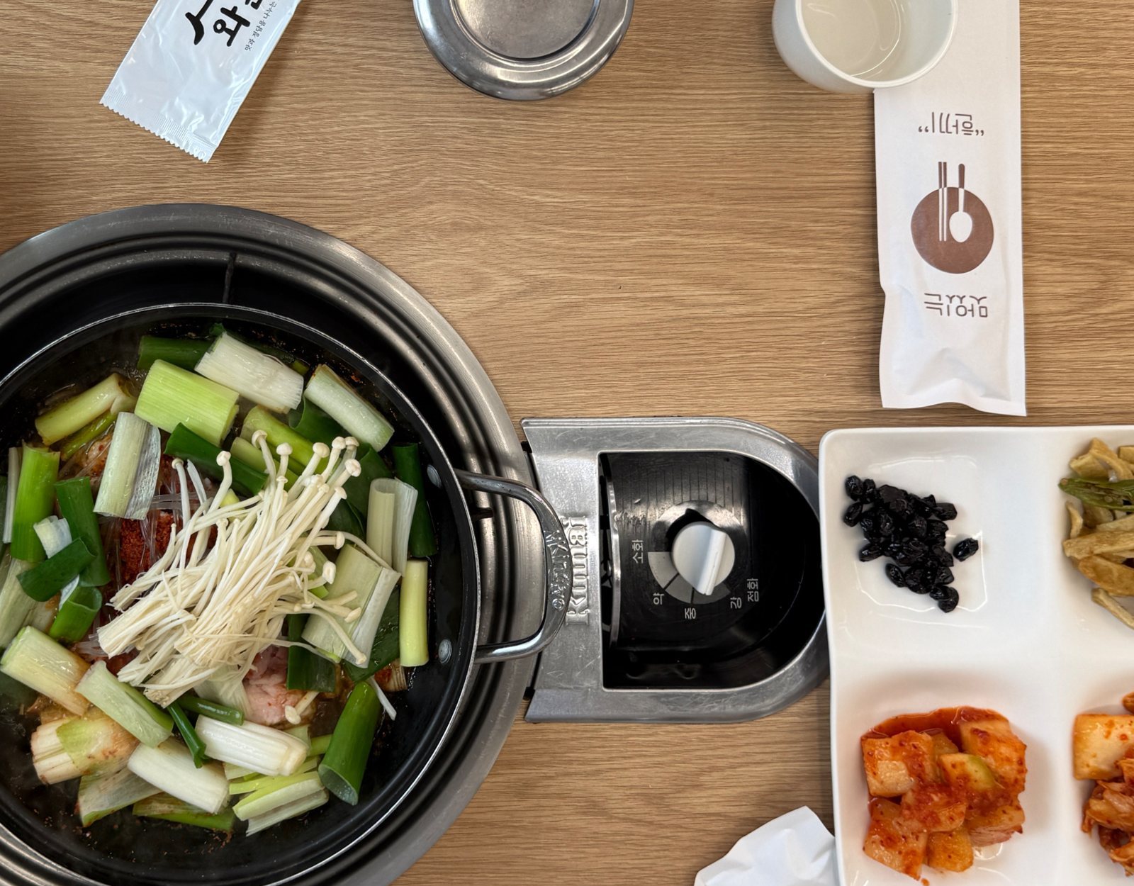 와촌돼지찌개 상차림 — 버너에 올린 넓은 냄비와 반찬(위에서 본 사진)